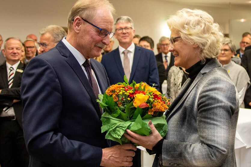 Mit einem Blumenstrauß verabschiedet sich Peter Dormanns bei der Schirmherrin des Bundeswehr-Sozialwerks, Ministerin Christine Lambrecht.